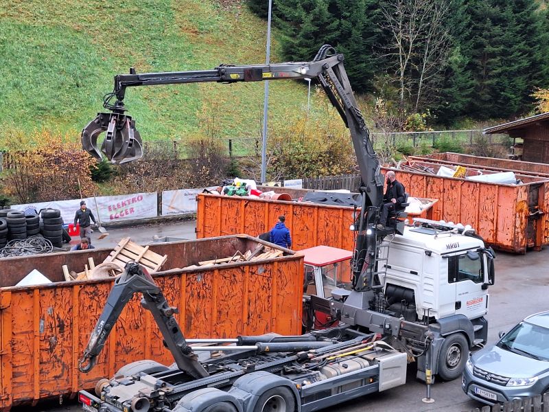 LKW lädt Sperrmüll in Container